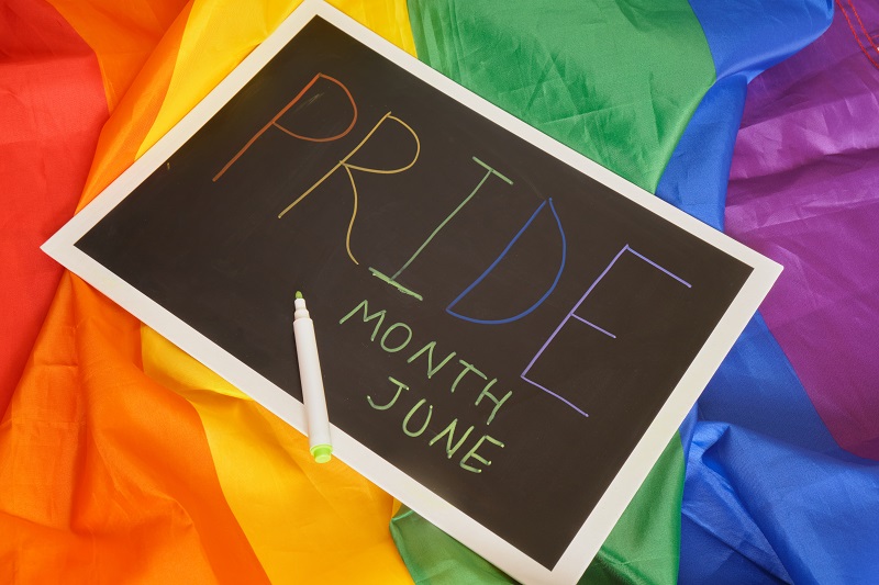 LGBT Pride Month in June. inscription pride month on black board on LGBT flag